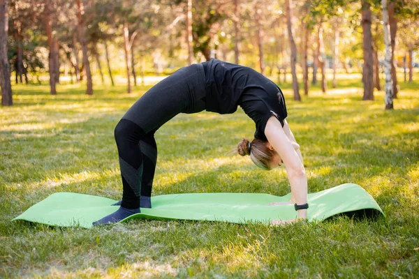 Girl Engaged Yoga Stands Bridge Pose Sports Mat Park — 스톡 사진