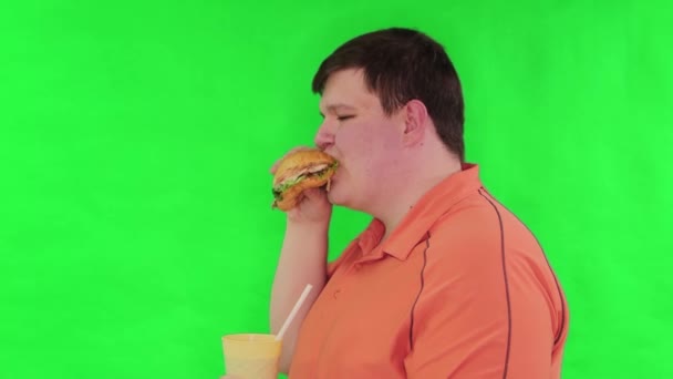 Portret Grubasa Jedzącego Wielkiego Hamburgera Pijącego Wodę Sodową Szklanki Słomką — Wideo stockowe