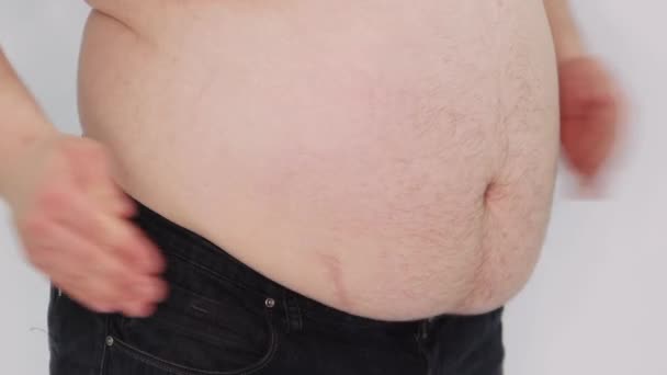 男性腹部紧闭 那个胖子用双手拍打他那光秃秃的大肚子 脂肪的褶皱抖动着 被白色背景隔离 — 图库视频影像