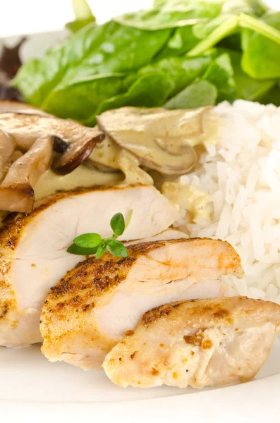 Kızarmış baharatlı tavuk göğsü kesilerek ve krem muchroom sosu, pilav ve salata ile servis edilir — Stok fotoğraf