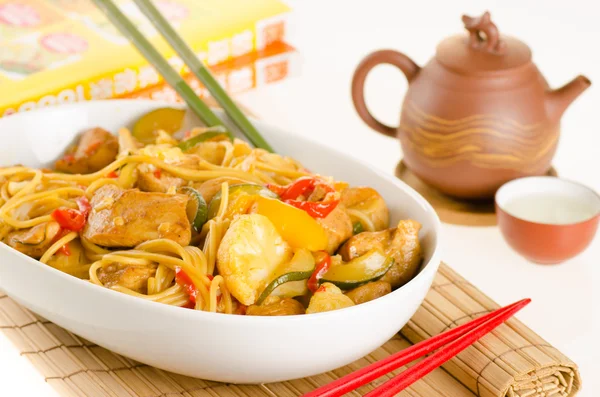 Stir-fried noodles with chicken and vegetables served in a bowl, — Stock Photo, Image