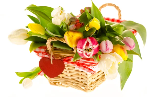 A bunch of colorful tulips in the basket with the heart isolated — Stock Photo, Image