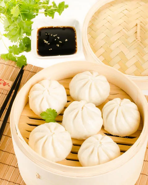 Chinese steamed buns in bamboo steamer basket with cilantro, soy — Stock Photo, Image