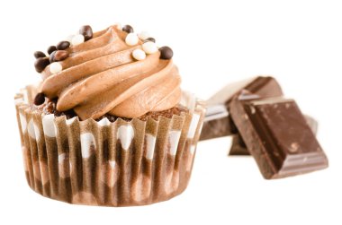Chocolate cupcake with chocolate icing and pieces of chocolate b