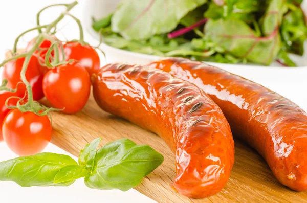 Embutidos a la parrilla con ensalada y tomates — Foto de Stock