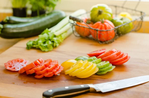 Mãos de mulher cortando tomate na cozinha — Fotografia de Stock