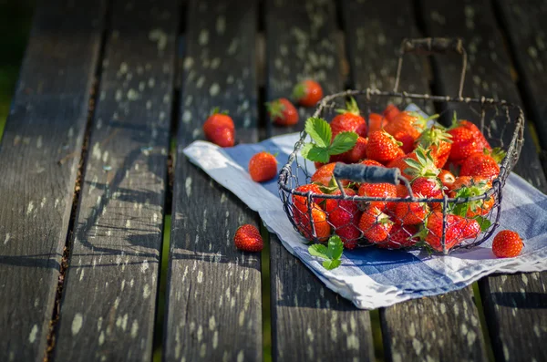 在旧花园木制桌上篮草莓 — 图库照片