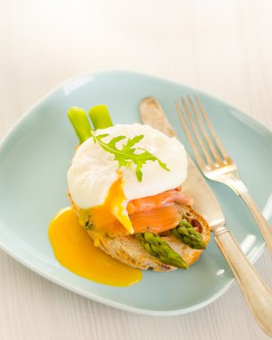 Poached eggs with salmon and asparagus on toasted bread clipart