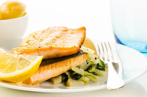 Филе жареной рыбы с овощным гарниром на белом — стоковое фото