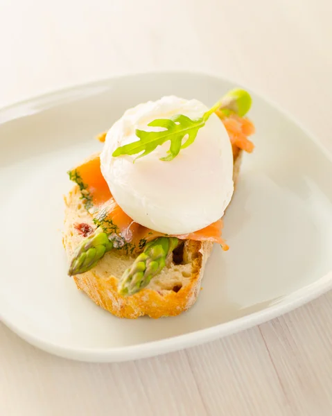 Poached eggs with salmon and asparagus on toasted bread — Stock Photo, Image
