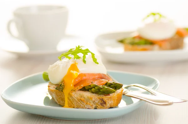 Huevos escalfados con salmón y espárragos sobre pan tostado —  Fotos de Stock