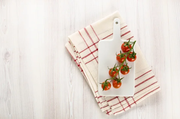 Vine of cherry tomatoes on the cutting board — Stock Photo, Image