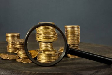 Kötü bir finans fikri. Farklı değerlerdeki paralar istiflenmiş. Bozuklukların büyüteçten görünüşü.