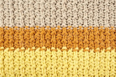 Örgü desenli yakın çekim. Sarı desen, terracotta ve açık kahverengi iplikler.