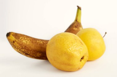 Beyaz arka planda sarı elma ve olgun muz izole edilmiş. Çirkin yemek konsepti. Seçici odak