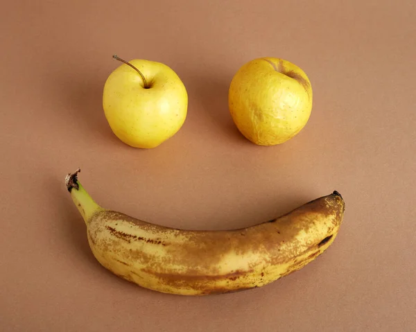 Pomarszczone Żółte Jabłka Przejrzały Banan Wyizolowany Jasnobrązowym Tle Brzydkie Jedzenie — Zdjęcie stockowe