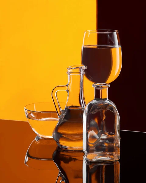 Різні Скляні Посуд Водою Барвистому Фоні Посуд Глянцевій Поверхні — стокове фото