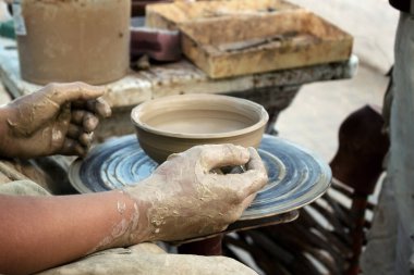 Usta çömlekçilik öğretiyor. Bir çocuğun elleri ve çamurdan yapılmış bir kase. Eğitim kavramı.