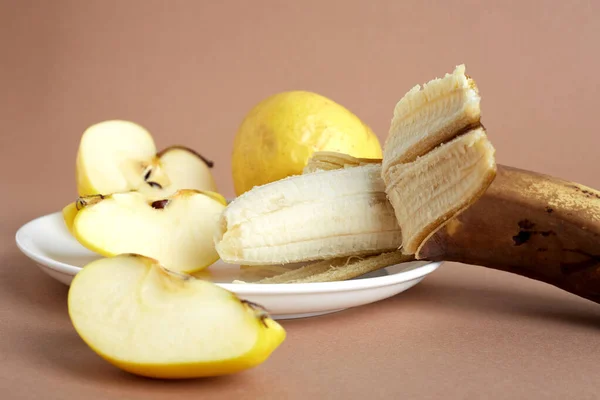 Zwiędłe Żółte Jabłka Przejrzały Banan Białym Talerzu Jedno Jabłko Jest — Zdjęcie stockowe