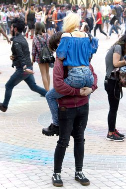 Kharkiv, Ukrayna, 19 Mayıs 2018 Holi renk festivali, adam kızı kollarına aldı, kız erkeği kucakladı. Çocuğun ve kızın yüzleri görünmüyor.
