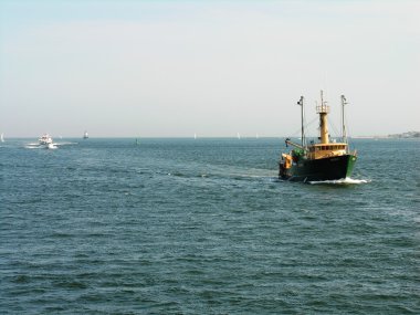 A Fishing boat approaching the harbor clipart