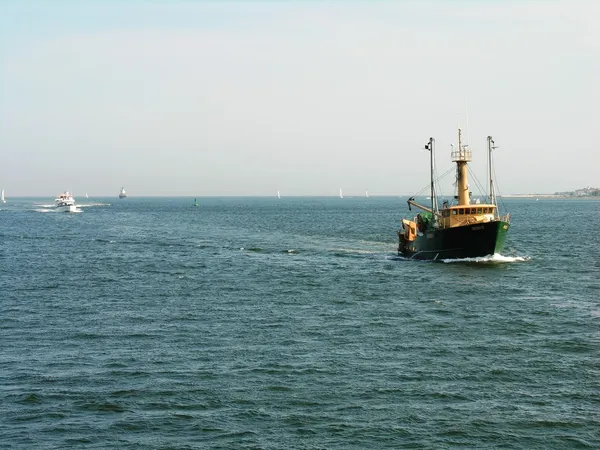 En fiskebåt som närmar sig hamnen — Stockfoto