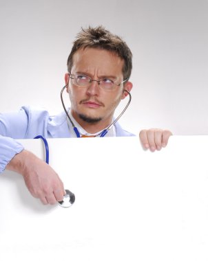 A doctor usin a Stethoscope over a white card. clipart