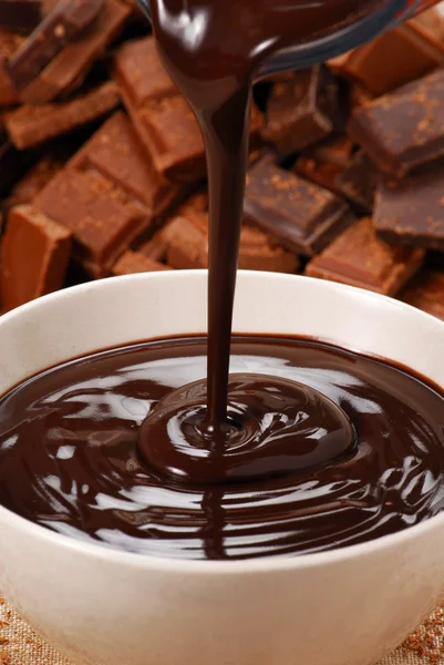 Pouring fresh chocolate cream on a white bowl. — Stock Photo, Image