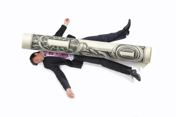 Business man squashed by a rolled bill on white background. — Stock Photo, Image