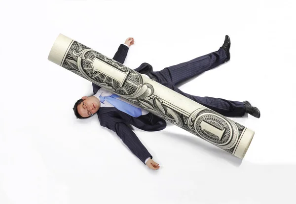 Business man squashed by a rolled bill on white background. — Stock Photo, Image