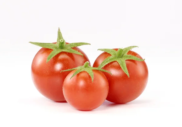 Tre små tomater på vit bakgrund. — Stockfoto