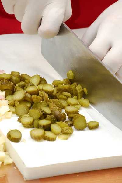 Cutting cucumbers on a white board. — Stock Photo, Image