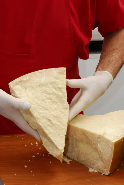 Hands holding a piece of Parmesan cheese. — Stock Photo, Image