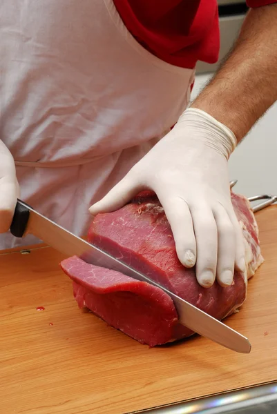 Cortar un trozo de carne fresca, cortar carne en la cocina . — Foto de Stock