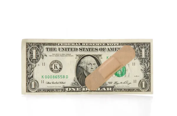 Conta de dólar com ajuda de banda adesiva no fundo branco . — Fotografia de Stock