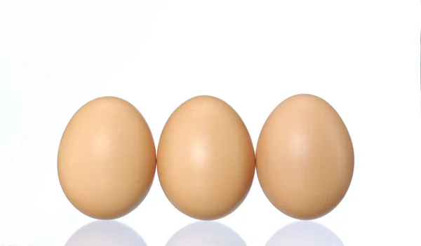 Beyaz zemin üzerinde üç taze yumurta. — Stok fotoğraf