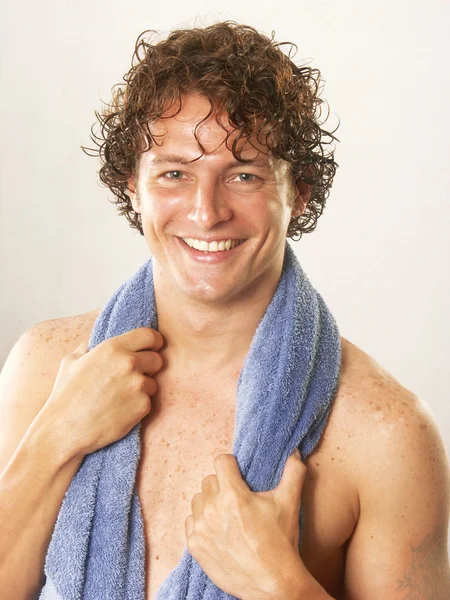Young man and blue towel on white background. — Stock Photo, Image