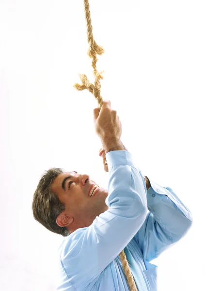 Man climbing a breaking rope. — Stock Photo, Image