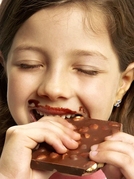 Маленькая девочка ест шоколад. — стоковое фото