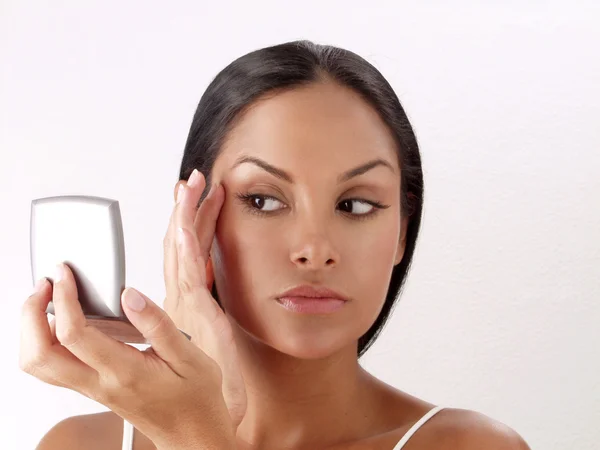 Mujer latina aplicando polvo de maquillaje sobre fondo blanco, maquillaje de mujer latina . — Foto de Stock