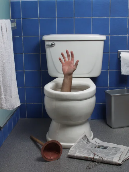 Hand reaches up through the seat from out of a toilet in a domestic bathroom. — Stock Photo, Image