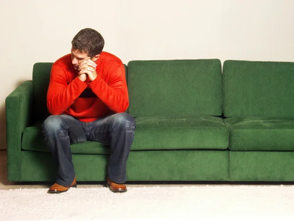 Ein Mann sitzt auf einem Sofa. — Stockfoto