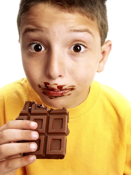 Primer plano de un chico divertido comiendo una barra de chocolate . —  Fotos de Stock