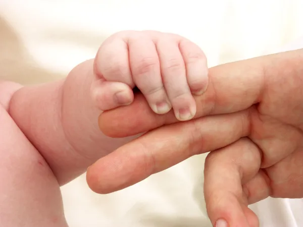 Baby holding daddies finger. — Stock Photo, Image