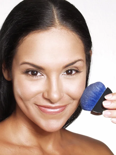 Latin woman applying blush on white background. — Stock Photo, Image