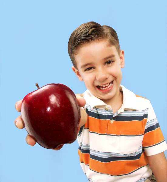 Liten pojke håller ett rött äpple. — Stockfoto