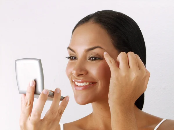 Mujer latina aplicando maquillaje —  Fotos de Stock