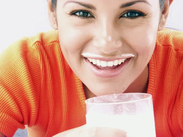 Mladí hispánský žena pije sklenici mléka. — Stockfoto
