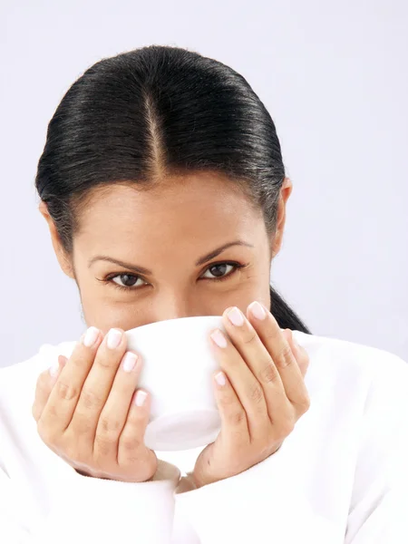 Mooie jonge vrouw met een kopje warme drank. — Stockfoto