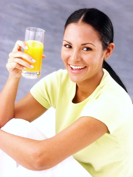 Jovem mulher latina bebendo suco de laranja — Fotografia de Stock